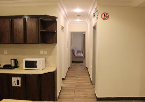a hallway leading to a kitchen with a microwave at Sea Club Resort in Dammam