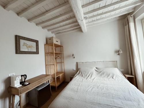 a bedroom with a white bed and a wooden desk at Villa Sofia in Querceta