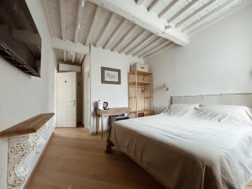 a white bedroom with a bed and a table at Villa Sofia in Querceta