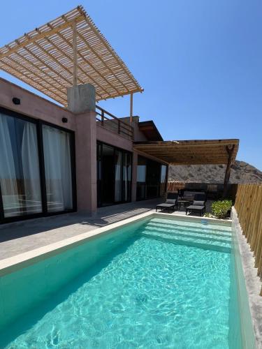 a villa with a swimming pool and a house at La Morada Punta Sal - Casa de playa frente al mar in Canoas de Punta Sal