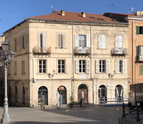 a large tan building with windows and balconies at Domo de Logu TÀTARI ANTIGA in Sassari