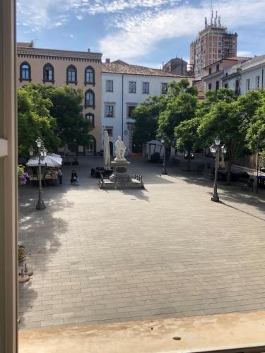a courtyard in a city with a fountain and buildings at Domo de Logu TÀTARI ANTIGA in Sassari