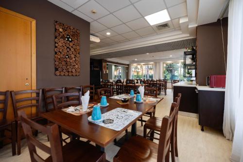 una sala da pranzo con tavoli e sedie in legno di Scheppers Hotel a Roma