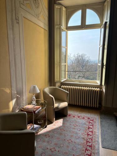a living room with a chair and a window at Villa Favorita in Bra