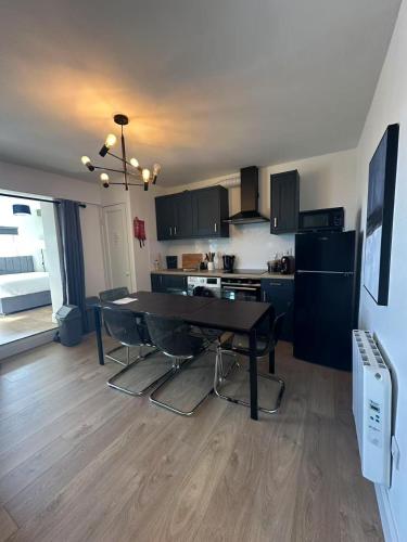 a kitchen with a dining table and a kitchen with black cabinets at Abbey Apartments in Dublin