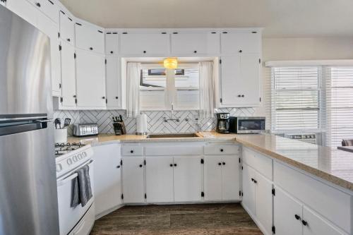 a white kitchen with white cabinets and a window at 118 Emerald Ave A & B in Newport Beach