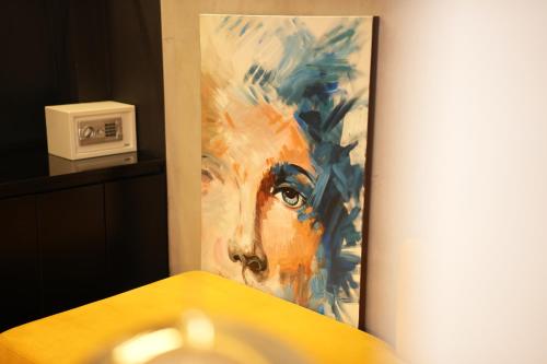 a painting of a mans face on a wall at La Suite Boutique Hotel in Tirana