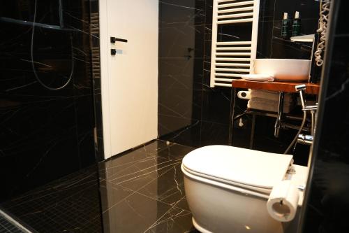 a bathroom with a white toilet and a shower at La Suite Boutique Hotel in Tirana