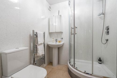 a bathroom with a toilet and a shower and a sink at Chunal Apartment Central Glossop in Glossop