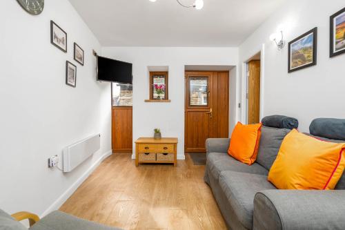 a living room with a couch and a tv at Chunal Apartment Central Glossop in Glossop