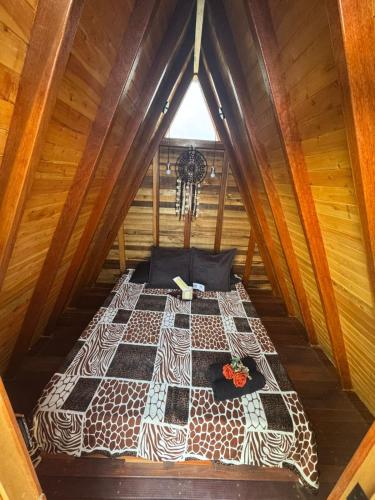 an overhead view of a bed in a wooden cabin at Mambe refugio in Piedecuesta