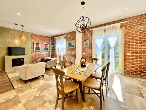 a dining room with a brick wall and a table and chairs at Villa Edmond in Tirana