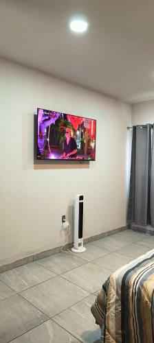 a room with a flat screen tv on a wall at Habitación Arándano in Ciudad Guzmán