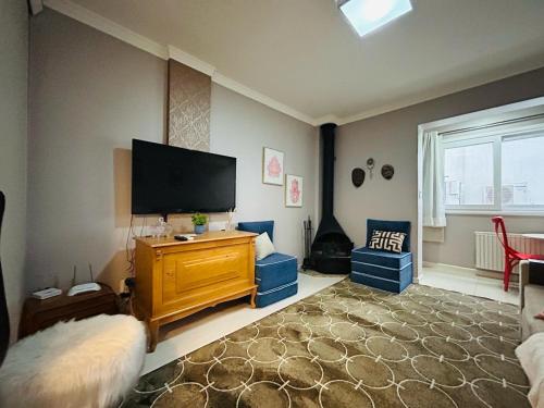 Schlafzimmer mit einem Flachbild-TV an der Wand in der Unterkunft 150 m da Catedral de Pedra - Centro de Canela in Canela