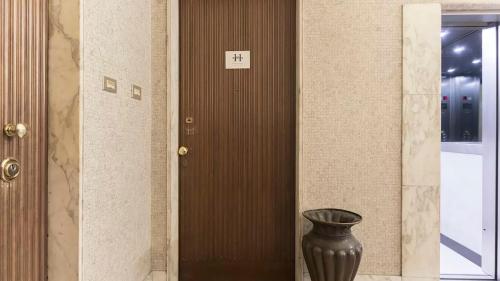 a black vase sitting in front of a door at Classbnb - Two apartments 400 meters from the Duomo in Milan