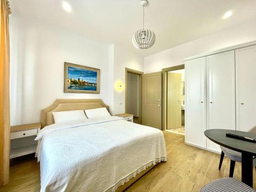 a bedroom with a large white bed and a table at Villa Edmond in Tirana