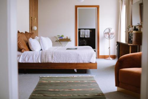 a bedroom with a bed with white sheets and a fan at Scotia Lodge in Scotia