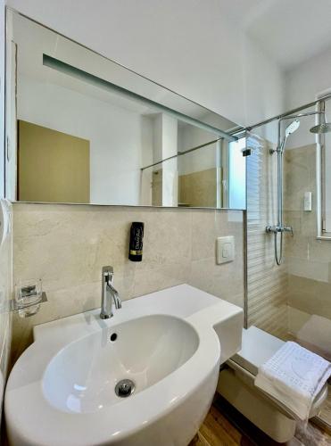 a white bathroom with a sink and a shower at Villa Edmond in Tirana