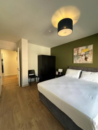 a bedroom with a large white bed and a chair at Abbey Apartments in Dublin