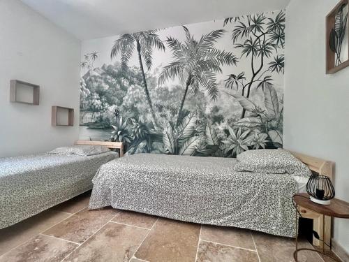 une chambre avec deux lits et une fresque de palmiers dans l'établissement Maison du Ventoux, à Mormoiron