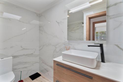 a white bathroom with a sink and a mirror at Hermosa Vista Tejina in Guía de Isora