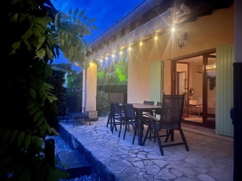 - une terrasse avec une table et des chaises la nuit dans l'établissement Maison du Ventoux, à Mormoiron