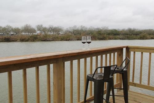 a glass of wine and two chairs on a wooden balcony at Rocket Ranch #1 - Mars in Brownsville