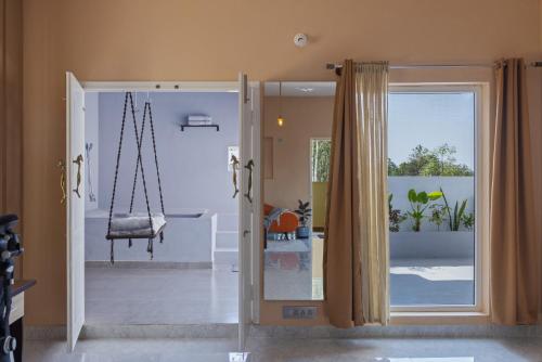 Moonlight Manor- Luxury Escape في بانغالور: غرفة مع أرجوحة وباب زجاجي منزلق