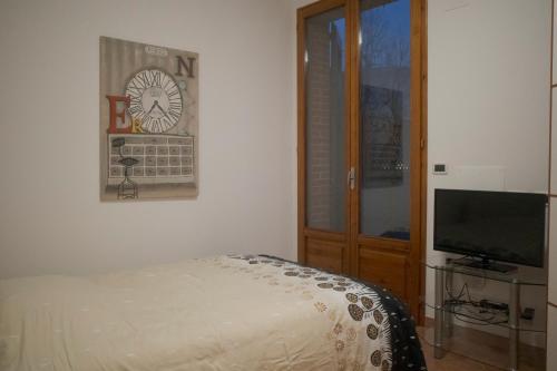 a bedroom with a bed and a flat screen tv at Casa Jack in San Giorgio di Piano