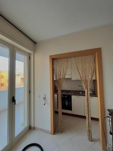a room with a kitchen with drapes on the door at Casa vacanze Colle della Minerva in Otranto