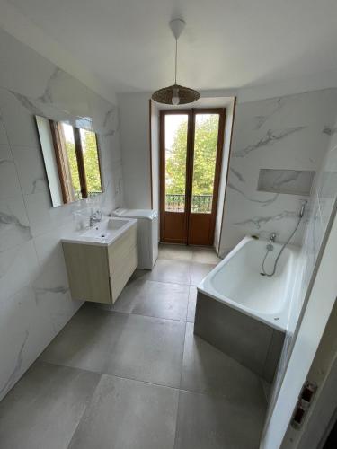 une salle de bain avec deux lavabos et une baignoire et une baignoire dans l'établissement Appartement Ronzier Joly, à Clermont-lʼHérault