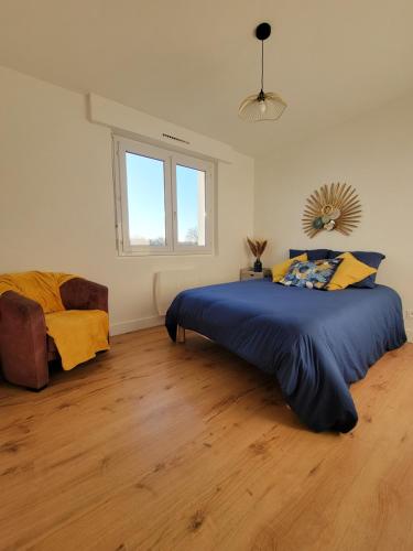 Un dormitorio con una cama con un edredón azul. en Le 102 - appart-sympa - T2, patio, jardin et cave - Larmor-Plage, en Larmor-Plage
