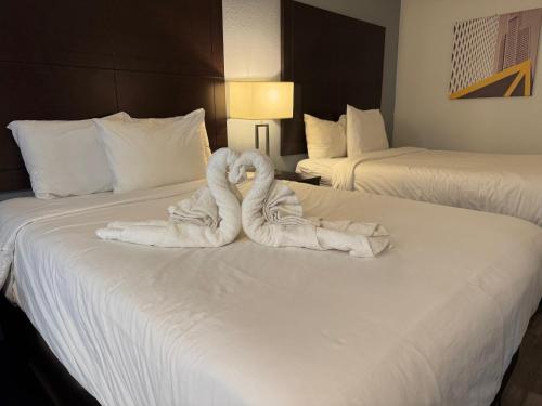 a hotel room with two beds with towels on them at Clarion Inn & Suites Dothan South in Dothan