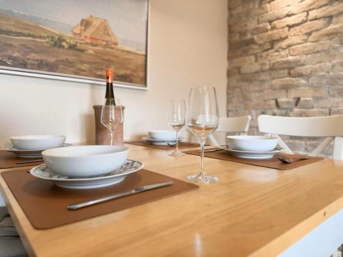 a wooden table with glasses and a bottle of wine at Lazy Osyter Sylt in Braderup