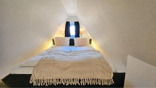 a bedroom with a bed in a room with a window at Lazy Osyter Sylt in Braderup