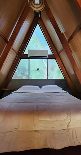 a bedroom with a large window in a roof at Pousada Cocobeach Adventure - Miracema do Tocantins in Palmas