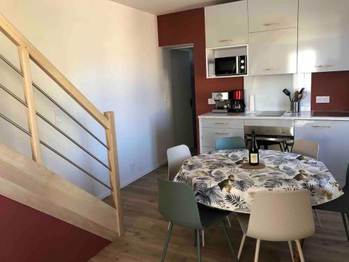 une cuisine et une salle à manger avec une table et des chaises dans l'établissement Maison Saumur, à Saumur