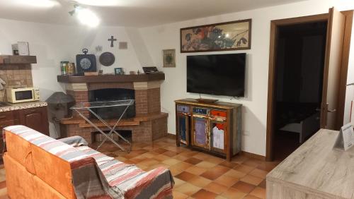 a living room with a couch and a television at Dimora La Risorgiva in Ca' di David