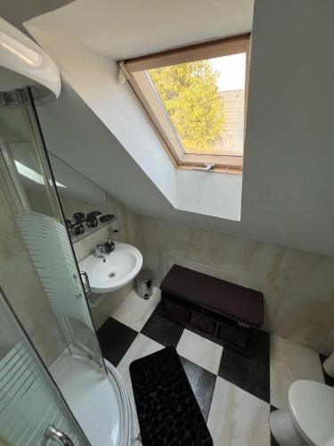 a bathroom with a sink toilet and a window at Izabella Vendégház in Balatonszárszó