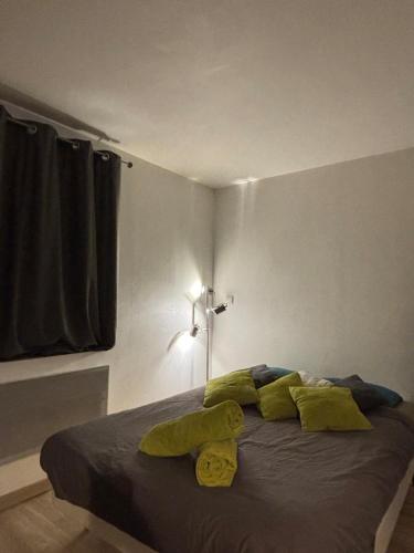a bedroom with a bed with green pillows on it at Studio 33, centre-ville, proche gare in Annecy