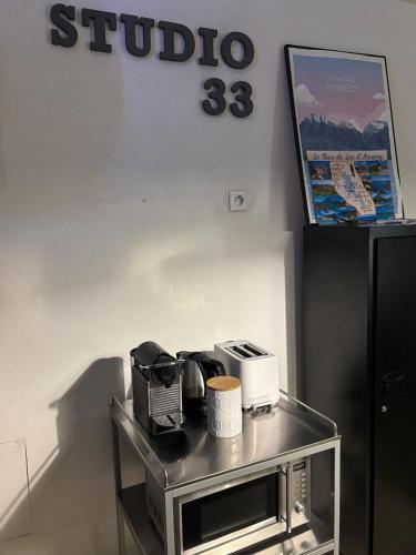 a table with a microwave and a sign on a wall at Studio 33, centre-ville, proche gare in Annecy