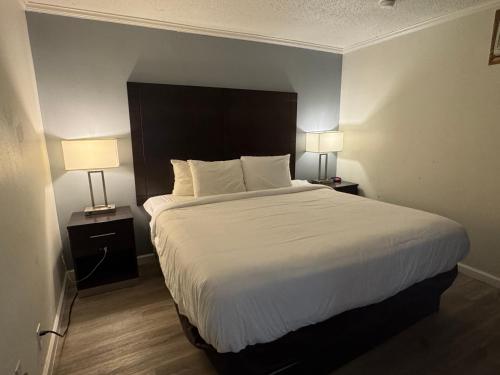 a bedroom with a large bed with two lamps on tables at Clarion Inn & Suites Dothan South in Dothan