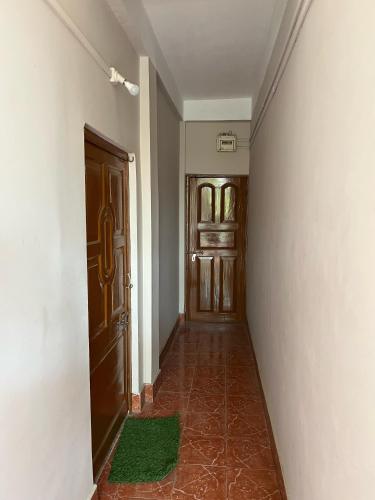 un corridoio vuoto con una porta e un tappeto verde di Heritage Inn Homestay Sivsagar a Sibsāgar