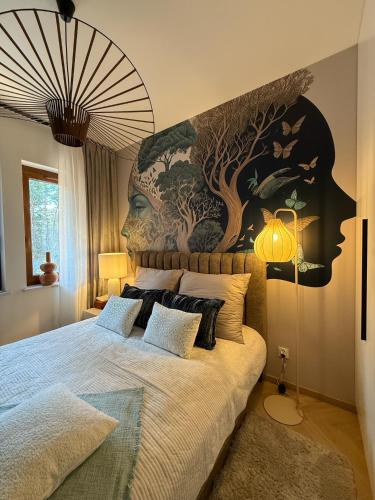 a bedroom with a bed with a large painting on the wall at Apartament Pod Żaglami 2 in Sława