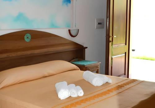 two rolls of towels are sitting on top of a bed at Hotel Cardedu in Cardedu