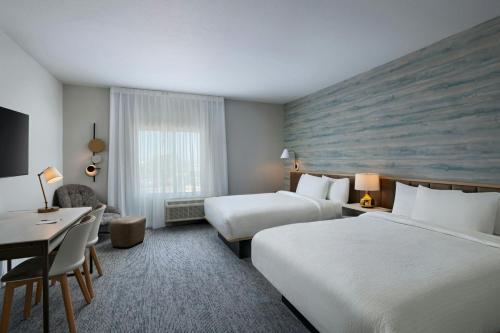 ein Hotelzimmer mit zwei Betten und einem Schreibtisch in der Unterkunft TownePlace Suites by Marriott Albuquerque Uptown in Albuquerque
