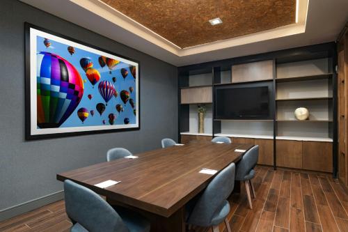 a conference room with a wooden table and a flat screen tv at TownePlace Suites by Marriott Albuquerque Uptown in Albuquerque