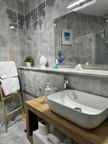 Un baño con un lavabo blanco y un espejo. en Villa Anna, en Meta