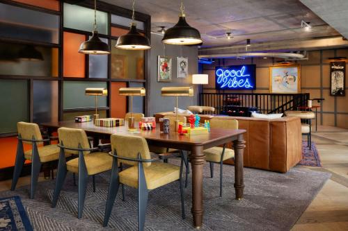 a restaurant with a table and chairs and a neon sign at Moxy Asheville in Asheville