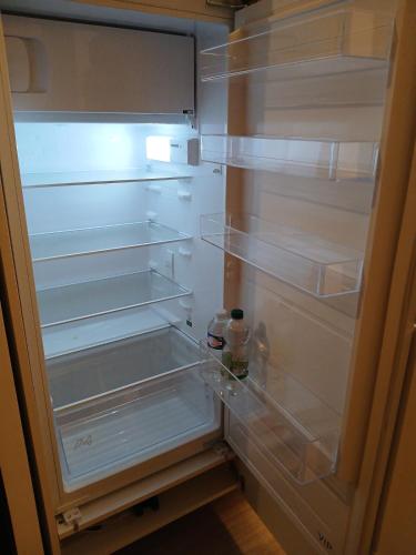 - un réfrigérateur vide avec une porte ouverte et une bouteille dans l'établissement très bel appartement 2 pièces, à Brétigny-sur-Orge